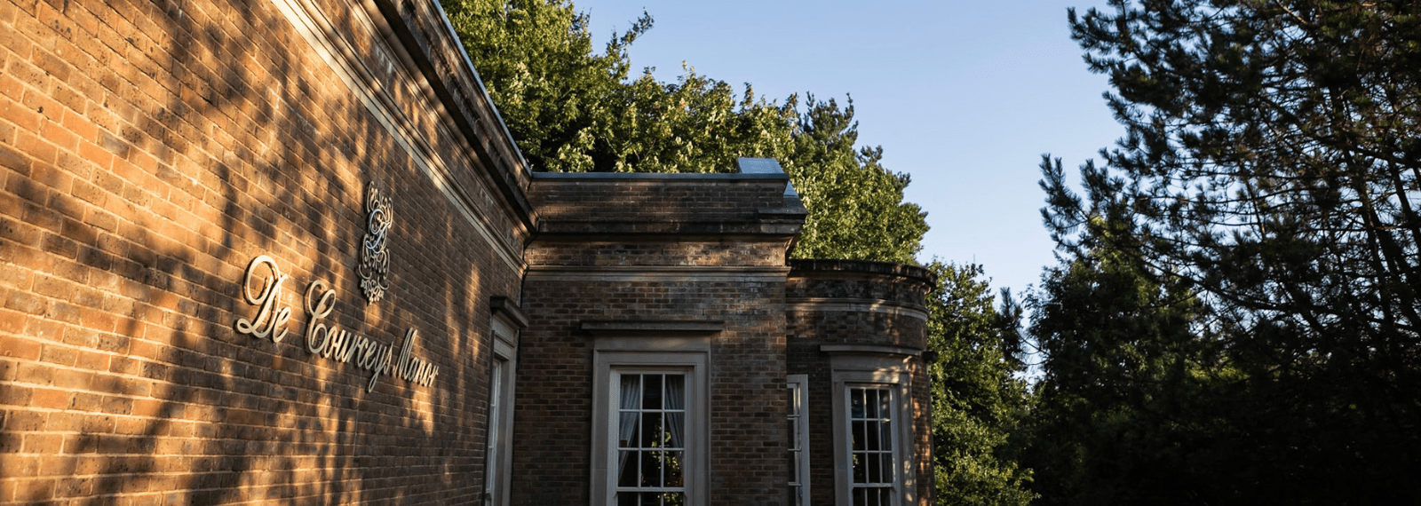 De Courceys Manor. a building with trees in the background